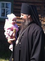 Владыка после литургии общается с младенцем