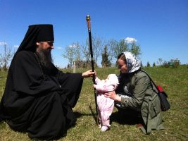 Владыка после литургии общается с младенцем
